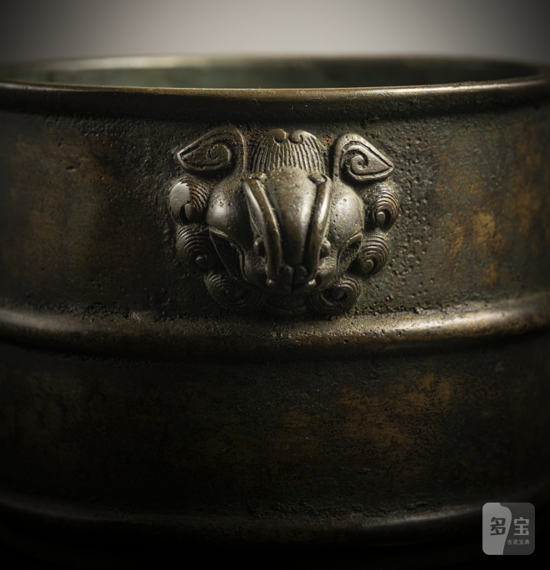 A cylindrical bronze incense burner in the shape of a cylindrical 'Lian' with relief burrs and mask handles on the sides - 图4